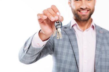 Anahtarları tutan gülümseyen genç adamın kırpılmış fotoğrafı.