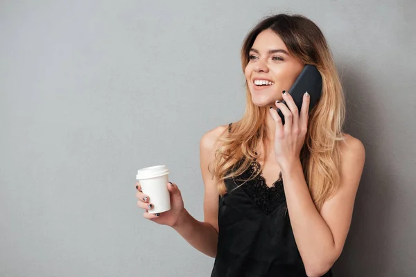 Lány beszél telefonon, miközben iszik menni kávéscsésze — Stock Fotó