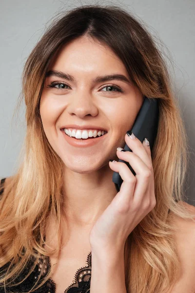 Retrato de uma menina de sorriso bonita que fala no telefone móvel — Fotografia de Stock