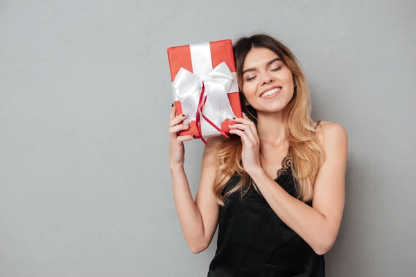 Vacker ung kvinna håller presentbox på hennes ansikte — Stockfoto