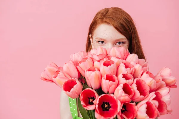 Close-up portret van de vrouw verbergen achter boeket bloemen — Stockfoto