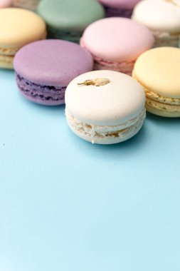 Mavi masa arka plan üzerinde tatlı renkli macaroons.