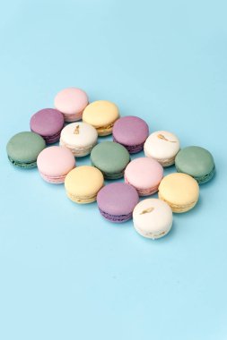 Mavi masa arka plan üzerinde tatlı renkli macaroons.