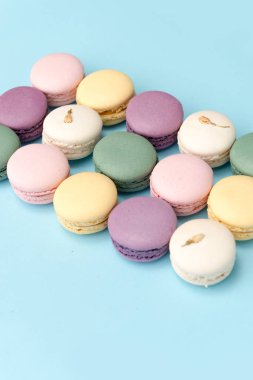 Mavi masa arka plan üzerinde tatlı renkli macaroons.