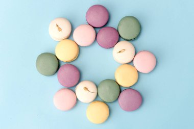 Mavi masa arka plan üzerinde tatlı renkli macaroons.