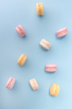 Mavi masa arka plan üzerinde tatlı renkli macaroons.
