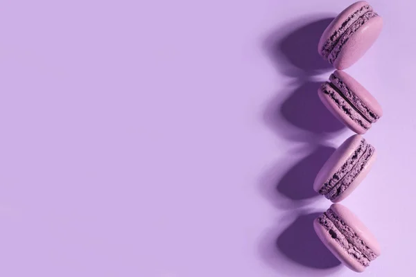 甜蜜紫蛋白杏仁饼干上紫色的表格背景. — 图库照片