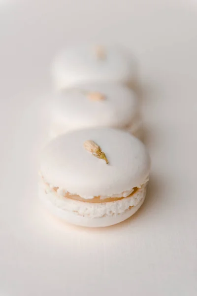 Macaroons brancos doces no fundo branco da tabela. — Fotografia de Stock