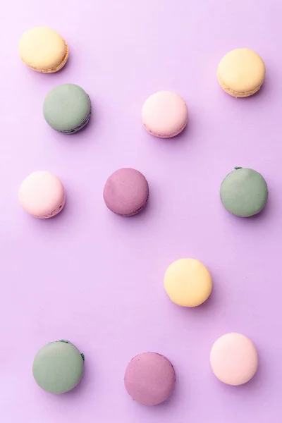 Sladké barevné makaroony na purpurovém pozadí tabulky. — Stock fotografie