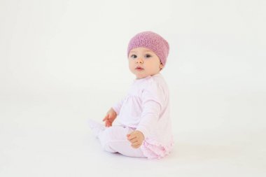 Sevimli küçük bebek kız yerde oturan şapka giyiyor