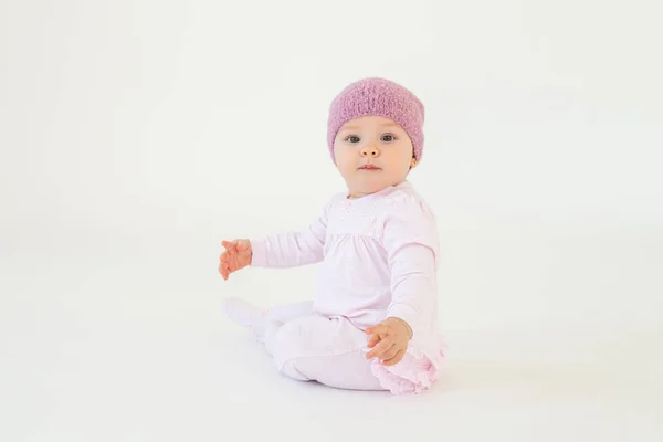 Χαριτωμένο μικρό μωρό κορίτσι φορώντας καπέλο κάθεται στο πάτωμα απομονωμένος — Φωτογραφία Αρχείου
