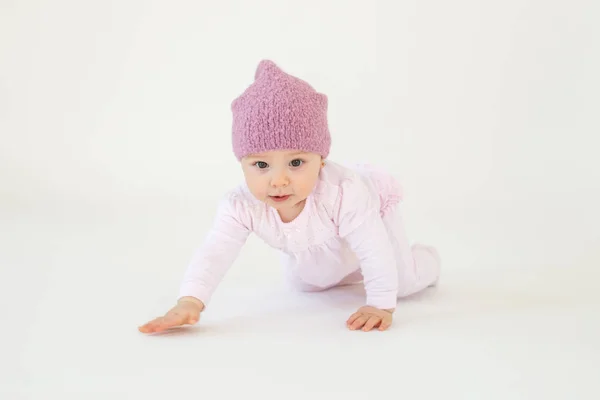Liten baby flicka bär hatt sitter på golvet isolerade — Stockfoto