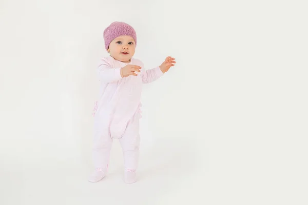 Söt liten baby flicka klädd i hatt stående på golvet — Stockfoto