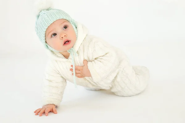 Pequeno bebê usando chapéu sentado no chão sobre fundo branco . — Fotografia de Stock