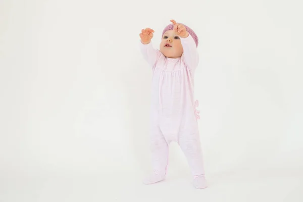 Baby flicka klädd i hatt stående på golvet isolerade — Stockfoto