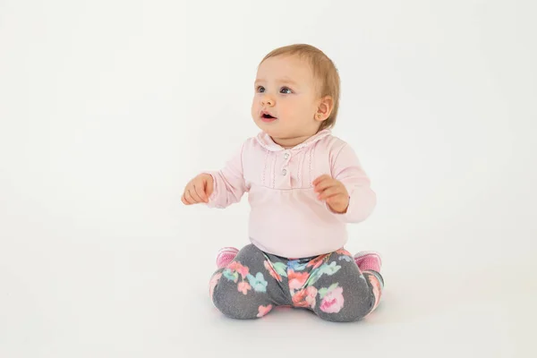 Baby flicka sitter på golvet isolerade över vit bakgrund. — Stockfoto