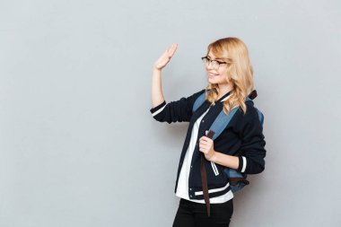 Sırt çantası ile gözlük takan mutlu genç bayan öğrenci