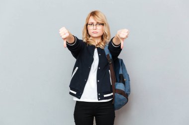 Başparmak aşağı gösterilen genç bayan öğrenci.