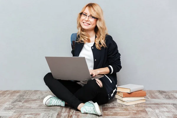 Sorridente giovane studentessa utilizzando computer portatile . — Foto Stock