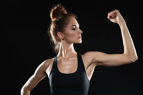 Jovem mulher esportiva mostrando seu bíceps — Fotografia de Stock