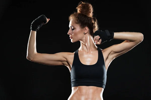 Allvarlig kvinnlig fighter visar hennes biceps — Stockfoto