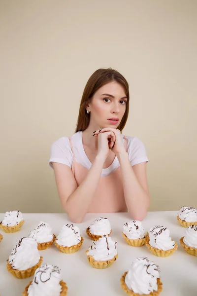Vertikales Bild einer ruhigen Frau am Tisch mit Kuchen — Stockfoto