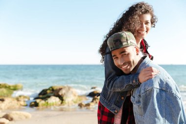 Açık havada kumsalda yürüyen Afrika sevgi dolu çift gülümseyen.