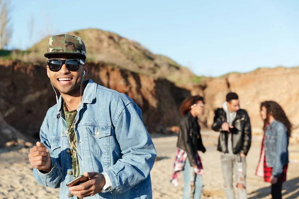 Afrikanischer glücklicher junger Mann hört Musik mit Kopfhörern — Stockfoto