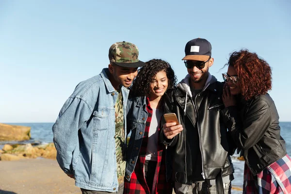 Gülümseyen Afrika arkadaşlar cep telefonunuzun ve açık havada yürüyüş.