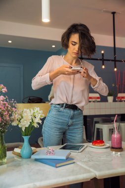 Pretty genç kız blogger cep telefonu ile fotoğraf çekme