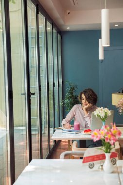 Dizüstü bilgisayar ile ödev dalgın genç kadın