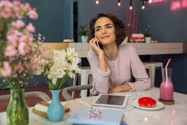 Mujer bastante joven hablando en el teléfono móvil mientras está sentado — Foto de Stock