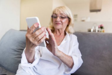 Bir smartphone kullanarak gözlük güzel üst düzey kadın