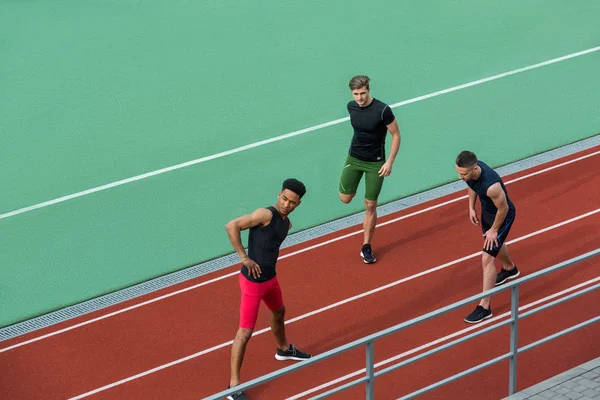 Ung multietniskt idrottsman gruppen göra stretchingövningar — Stockfoto