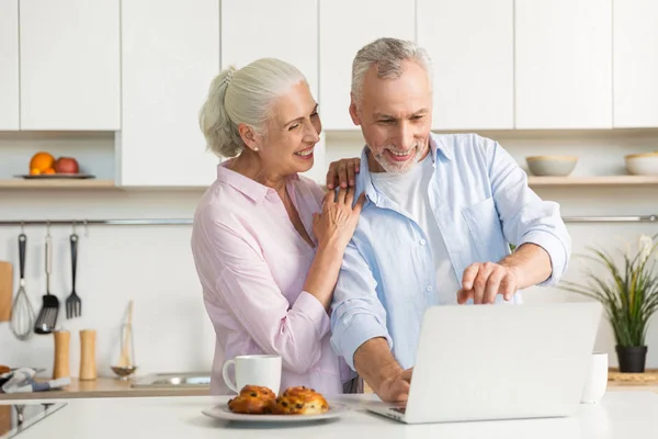 Sorrindo madura família casal amoroso usando computador portátil — Fotografia de Stock