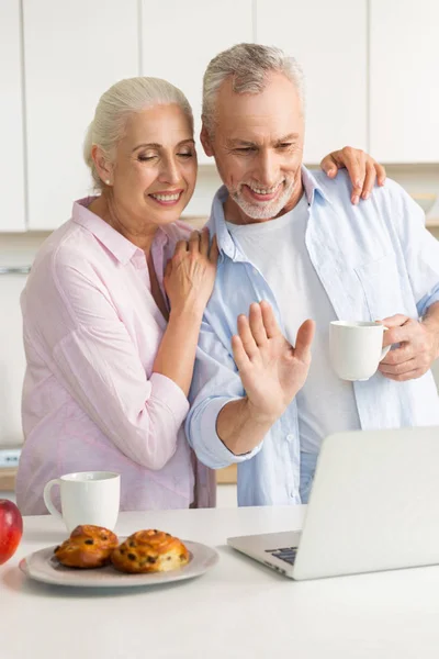 Alegre pareja madura amante de la familia en la cocina utilizando el ordenador portátil — Foto de Stock