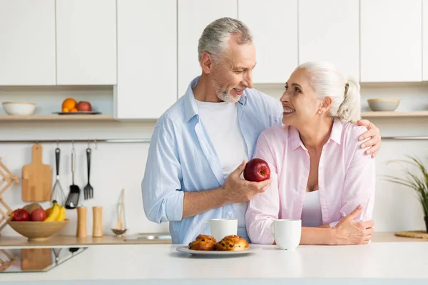 Sonriendo pareja madura amorosa familia de pie en la cocina — Foto de Stock