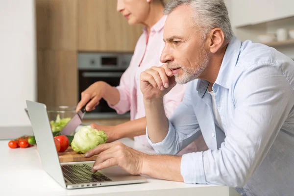 Maduro amante pareja familia usando portátil y cocina ensalada — Foto de Stock