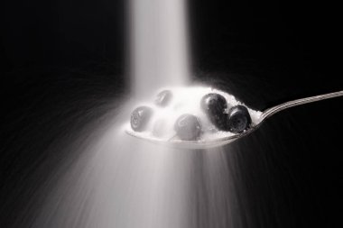 Siyah arka plan üzerinde izole yaban mersini kaşıkla.