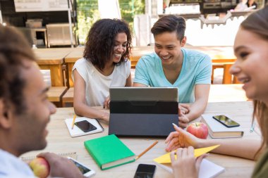 Neşeli genç çok ırklı arkadaşlar öğrenciler açık havada tablet kullanma