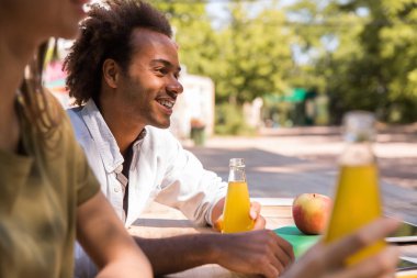 Açık havada juicee içme neşeli genç çok ırklı arkadaşlar öğrenciler.