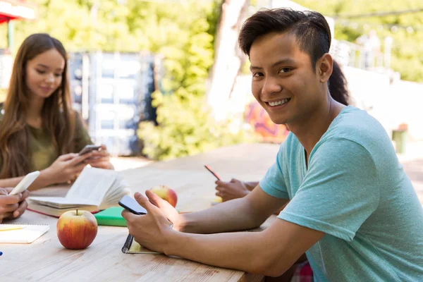 Lachende jonge multi-etnisch vrienden studenten met behulp van mobiele telefoons — Stockfoto