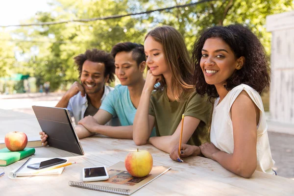 Heureux jeunes amis multiethniques étudiants en plein air en utilisant une tablette — Photo