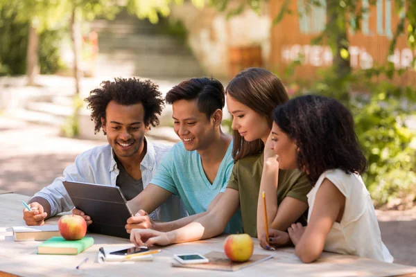 Sorrindo jovens amigos multiétnicos estudantes ao ar livre usando tablet — Fotografia de Stock