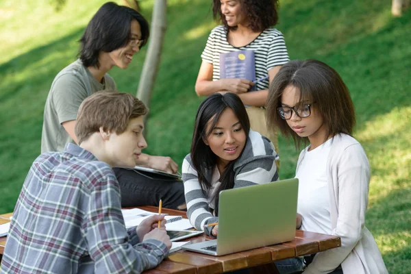 Mutlu grup oturma ve okuyan genç öğrenci