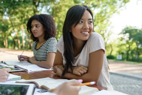 Gruppo multietnico di giovani studenti seduti e che studiano — Foto Stock