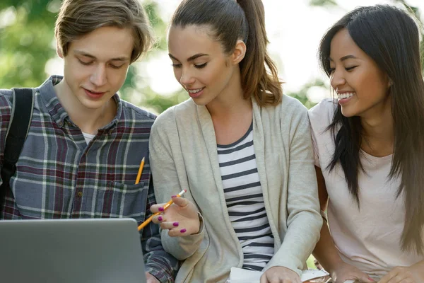 Multietnisk grupp unga leende studenter använder bärbar dator — Stockfoto