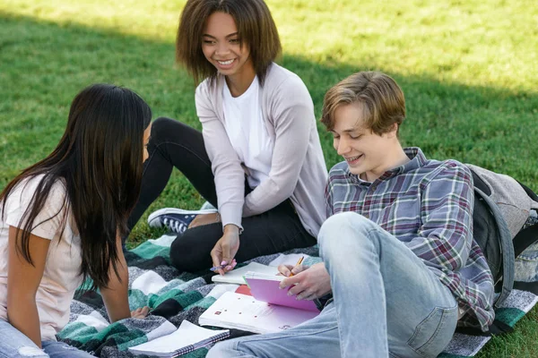Açık havada okuyan öğrenciler gülümseyerek. Bir kenara arıyorsunuz.