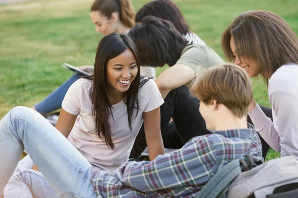 Açık havada okuyan öğrenciler gülümseyerek. Bir kenara arıyorsunuz.
