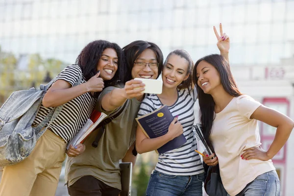 Happy students standing and make selfie outdoors — Stock Photo, Image